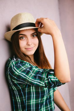 Kameraya bakarak ve gülümseyen şapkalı genç kadın