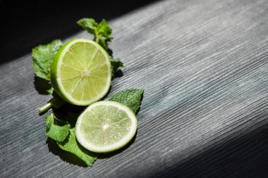 Kireç ve naneli limonata veya mojito, siyah arka plan üzerine gıda kavramı için malzemeler olarak