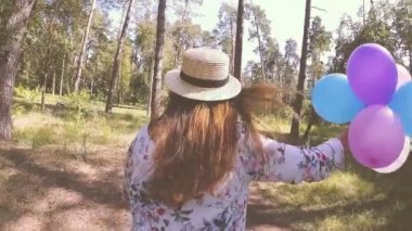 Hava balonları ile şapkalı güzel genç kadın yaz aylarında açık havada çalıştırmak