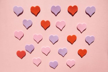 Pastel pembe arka plan, sevgi ve Sevgililer günü kartı kırmızı ve mor kalp şekilleri