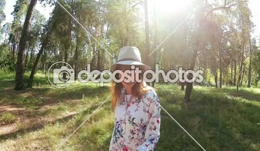 Gülümseyen ve yaz aylarında Park'ta dans şapkalı güzel kadın