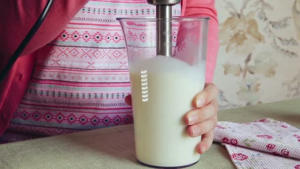 キッチンでブレンダーを使用して ミルクとバナナでミルクカクテルを作る美しい女性 — ストック動画