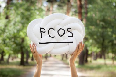 PCOS - Polycystic ovary syndrome, woman sickness lettering on white background in womans hands clipart