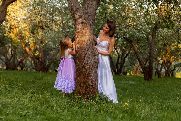 Bride and girl play by the tree — Stock Photo, Image