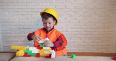 Neşeli gülümseyen çocuk Lego oluşturmak yoluyla