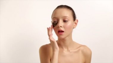 Göz cilt güzellik. Güzel genç kadın Model doğal yüz makyaj ve göz bakım ürünü yüz beyaz zemin üzerine Under portresi. ProRes