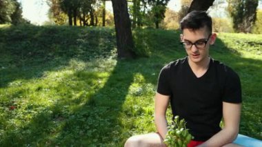 Kap içinde yetişen Basil 'in genç tohumları, Sağlıklı ve yoğun yeşil yapraklar. Gözlüklü genç bir adam iki leğen fesleğeni iki eliyle tutuyor ve ona hayret ediyor. Sağlıklı bir yaşam tarzı kavramı. Dualar