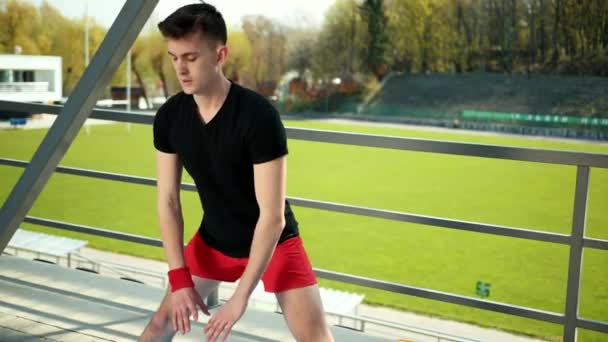 Homem desportivo jovem fazendo Ashtanga Yoga perto do estádio. Conceito de Liberdade, Saúde e Yoga. Prores, câmera lenta — Vídeo de Stock