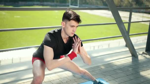 Junger, sportlicher Mann beim Aschtanga-Yoga in der Nähe des Stadions. Freiheit, Gesundheit und Yoga-Konzept. Prores, Zeitlupe — Stockvideo