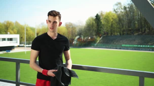 Beau jeune homme essuie la sueur d'un visage après le sport et le yoga. Chaleur estivale. Concept d'un mode de vie sain. Prores, au ralenti — Video