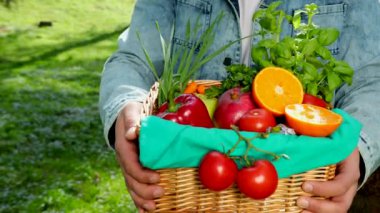 Mutlu genç bir çiftçi taze sebze bir sepeti tutan portresi. Arka plan doğa biyolojik, biyolojik ürünler, biyo ekoloji, kendi elleriyle, vejetaryen, salata sağlıklı yetiştirilen kavramı üzerinde