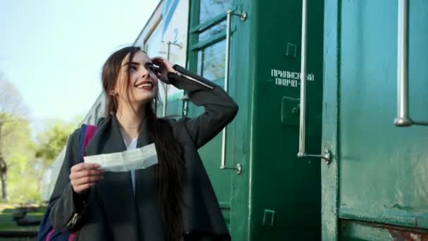 Çekici bir genç kadın trenle seyahat eder, bir yolculuk için satın alınan bilet bakar ve onun tren vagonu numarasını arar. — Stok video