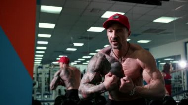 Yakışıklı bir atletik erkek vücut geliştirmeci onun kasları gösterir