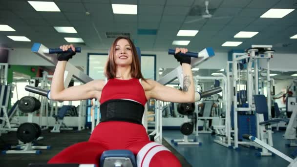 Beautiful girl doing exercises on device, increasing biceps on her hands. — Stock Footage Beautiful girl doing exercises on device, increasing biceps on her hands. Stock Video