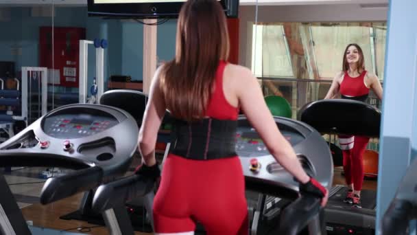 Bella donna sono in esecuzione sulla macchina in palestra, facendo allenamento cardio sul tapis roulant — Video Stock