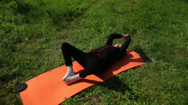 Mujer mayor acostada en una esterilla de yoga, dobló los brazos y las piernas y las movió hacia arriba, hacia abajo — Vídeo de stock