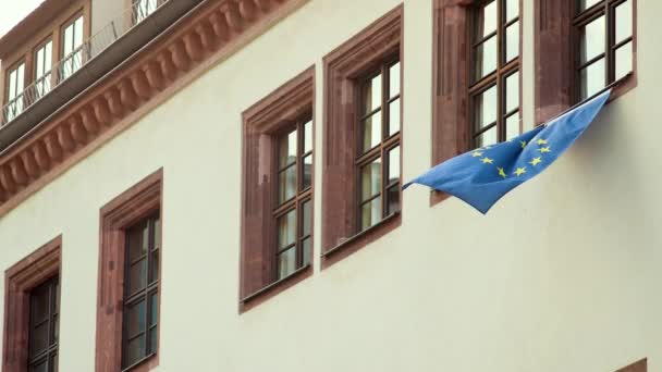 De vlag van de Europese Unie hangt op één venster van het gebouw — Stockvideo