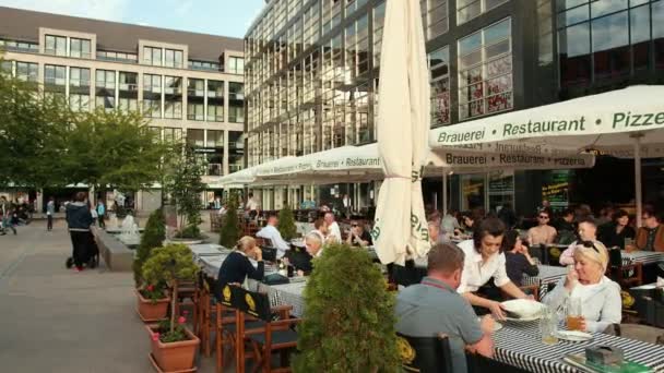 Los turistas se sientan en las mesas de un acogedor restaurante europeo. Degustación de deliciosos platos — Vídeo de stock