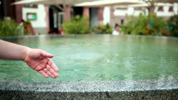 Hombre mojado mano está jugando con agua en la fuente — Vídeo de stock