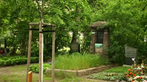 Starý hřbitov s různými památkami, rodinné hroby, lavičky, stromy v Evropě. — Stock video