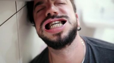Bıyıklı ve sakallı, ağzı yaygın, güçlü hava akımı ona üflür..