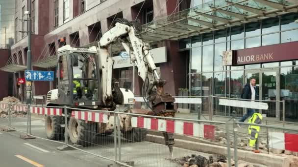 Ciągnik z młotem hydraulicznym niszcząc powierzchnię asfaltu — Wideo stockowe