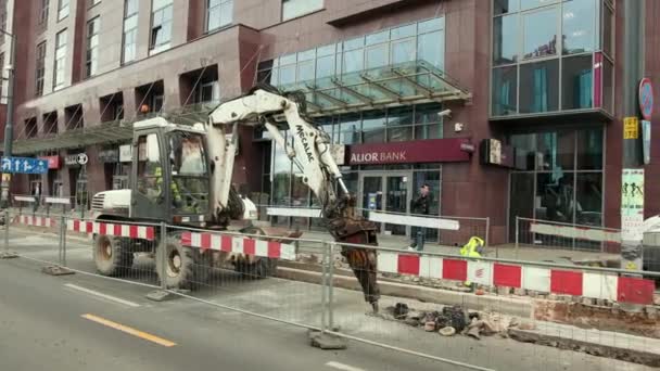 Ciągnik z młotem hydraulicznym niszcząc powierzchnię asfaltu — Wideo stockowe