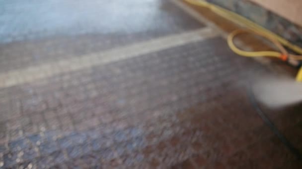 Mann, Putzfrau, wäscht Kopfsteinpflaster mit Hochdruckwasser, Nahaufnahme — Stockvideo