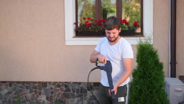 Person in a white t-shirt washes cobblestones with a jet of high pressure water — Stock Video