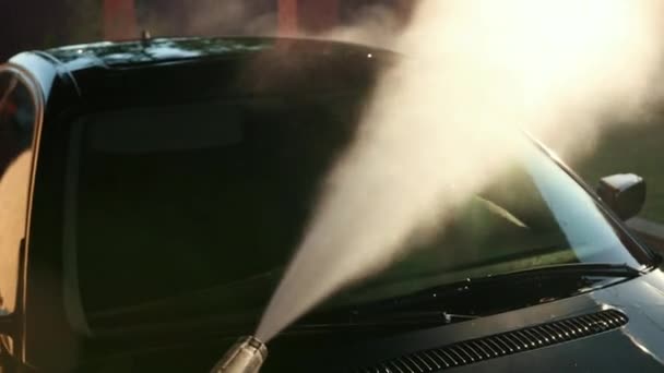 Arbeiter wäscht Auto, wäscht mit Hochdruck-Wasserstrahl. Spritzer breiten sich seitlich aus — Stockvideo