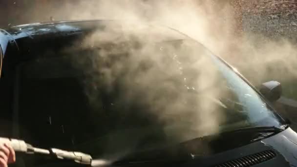 Travailleur voiture homme, lavage de voiture à l'aide de jet d'eau haute pression. le soleil brille — Video