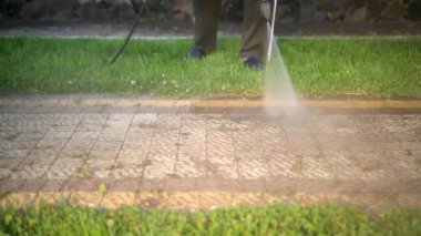 adam evin yakınında temizler, döşemeyı yıkar, yüksek basınçlı su jetleri ile yıkama kullanır