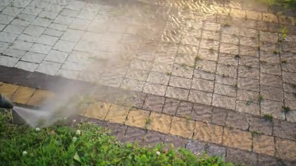 Male, cleaner, washes cobblestones with a jet of high pressure water, close-up — Stock Video