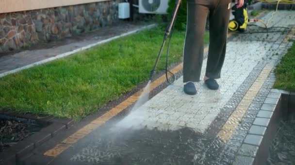 Чоловік, прибиральник, миє бруківки струменем води високого тиску, крупним планом — стокове відео