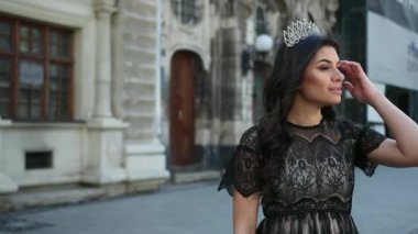 güzel kız koyu saçlı, siyah elbiseli, başında taç, kamera için poz