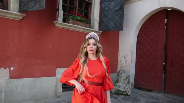 Girl, blonde, in a red dress, a crown on his head, posing for the camera — Stock Video