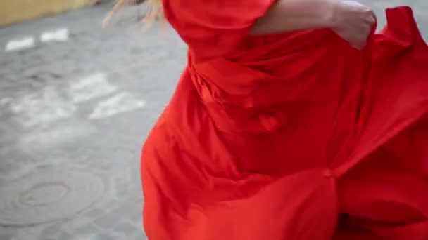 Chica en exquisito vestido rojo posando delante de la cámara en la calle, tiro lento — Vídeo de stock