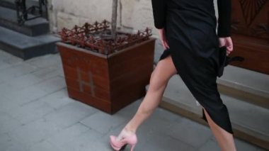 ince kız, siyah elbiseli, yüksek topuklu pembe ayakkabılar, sokakta yürürken