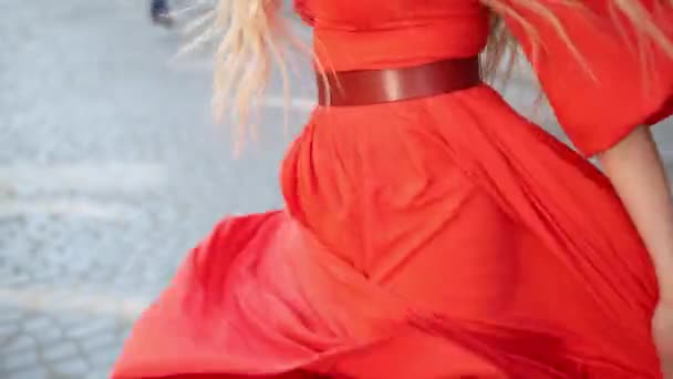 Девушка в изысканном красном платье позирует перед камерой на улице, медленная съемка — стоковое видео