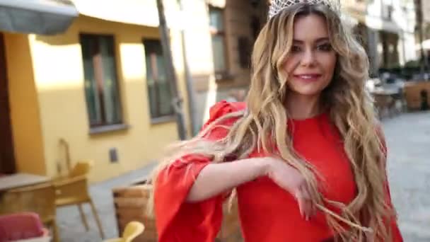 Girl, blonde, in a red dress, a crown on his head, posing for the camera — Stock Video