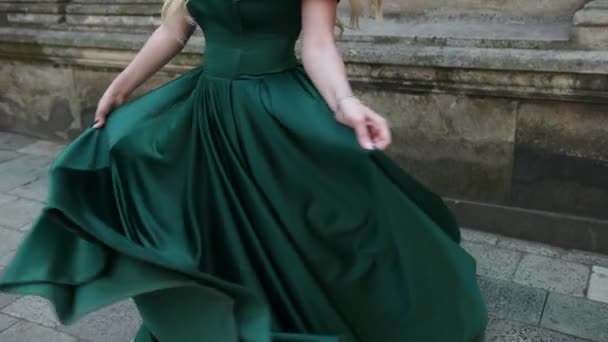 Стройная девушка, в зеленом платье, позирует и крутится перед камерой, крупным планом — стоковое видео