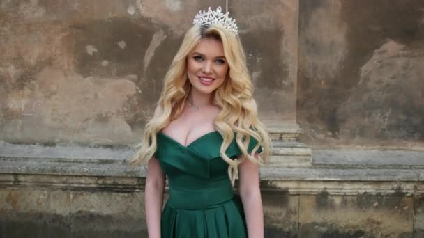 Miss, blonde, in groene jurk met blote schouders, met kroon, poseren voor camera — Stockvideo