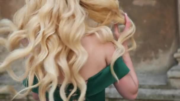 Slečna, blondýna, v zelených šatech s holýma rameny, s korunou, pózovat pro fotoaparát — Stock video