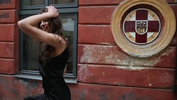 Miss, brunette, zwarte jurk, met heldere make-up, kroon, poseren in de straat — Stockvideo