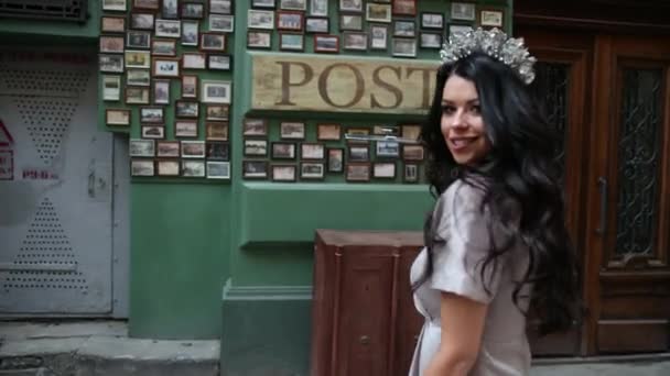 Morena miss, en vestido gris, piernas delgadas, maquillaje brillante, corona en la cabeza, posando — Vídeo de stock