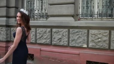 dantel ile koyu mavi uzun elbiseli kız esmer, bir taç ile, kamera için poz