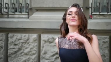 dantel ile koyu mavi uzun elbiseli esmer kız, taç ile, kamera için poz