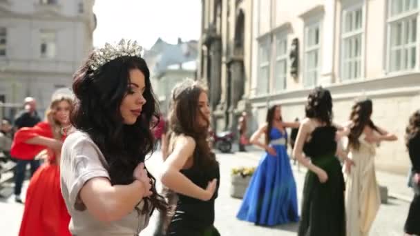 Muitas meninas bonitas vestidas com vestidos e coroas dançando na rua — Vídeo de Stock