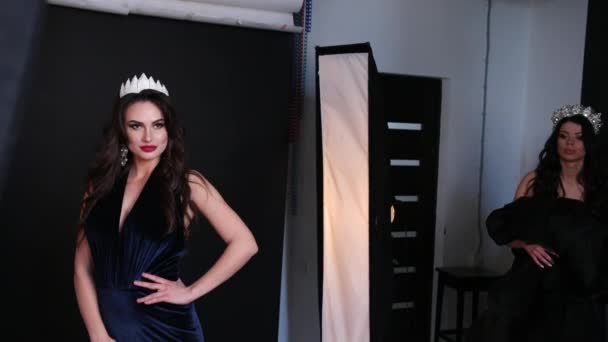 Chica morena en un vestido negro, con un escote profundo, sesión de fotos en el estudio — Vídeos de Stock