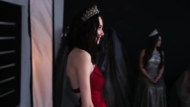 Pemotretan di Studio, seorang gadis berambut cokelat dengan gaun merah. dengan leher yang dalam — Stok Video